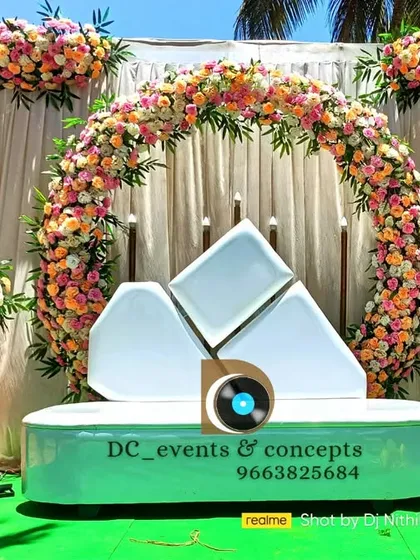 A fresh and contemporary Mehendi ceremony setup. The circular floral arch is paired with a unique geometric sofa in a cool mint green, creating a fun and stylish look for a daytime event.