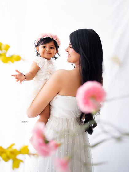 A beautiful over-the-shoulder shot of a mother holding her smiling baby.