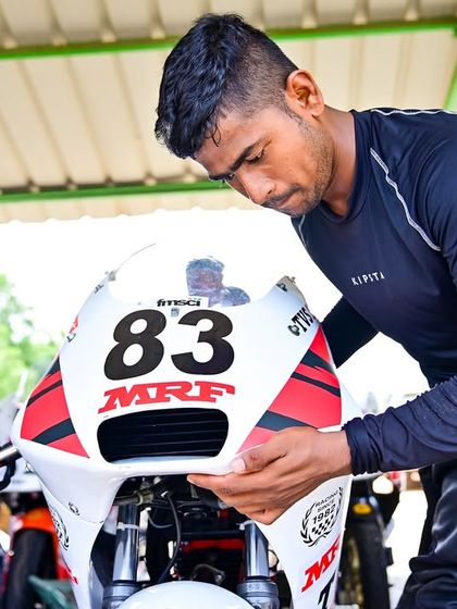 A rider making adjustments to his race bike in the pits. Meticulous preparation and a deep understanding of the machine are crucial for success.