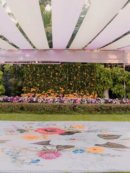 A wide view of a garden Haldi setup, featuring a custom-printed floral dance floor. This unique detail adds a personalized touch and enhances the overall theme of the event.