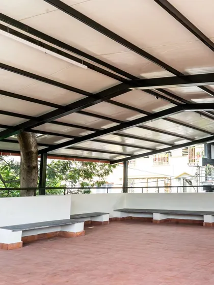 This semi-open terrace at an Anganwadi was designed to be a joyful, safe, and multi-functional space for children. The sloped roof provides protection from the sun, while the handmade terracotta tiles keep the floor cool. Built-in granite benches around the edge offer ample seating, leaving the floor open for play and community activities.