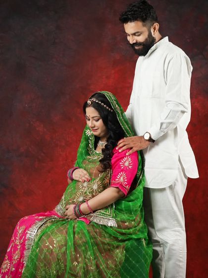 The husband-to-be gently places his hand on his wife's shoulder. This pose, in traditional Rajasthani clothes, shows support and love in a culturally rich setting.