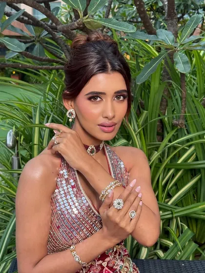 A playful and confident pose. The makeup is designed to be long-lasting and vibrant, perfect for a high-energy Garba or Dhol night.