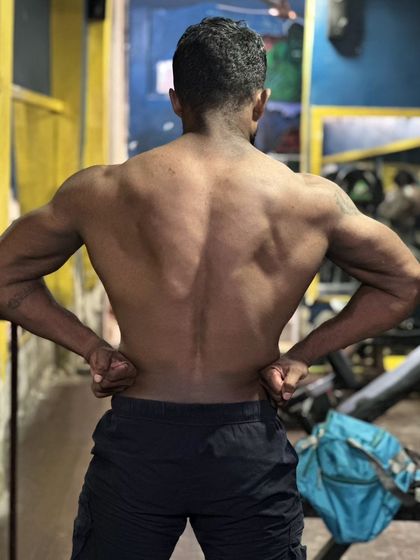 A back lat spread pose. A wide and thick back is essential for stabilizing heavy weight in all three powerlifts.