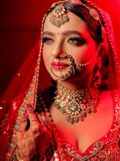 The perfect bridal portrait under dramatic red lighting. The makeup was designed to be flawless from every angle, with bold red lips and defined eyes that stand out beautifully.