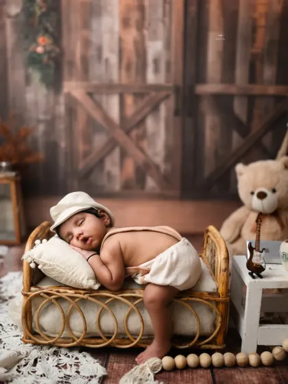 A newborn naps on a miniature cane bed, creating a cozy and rustic scene. I ensure every pose is safe and comfortable for your little one.