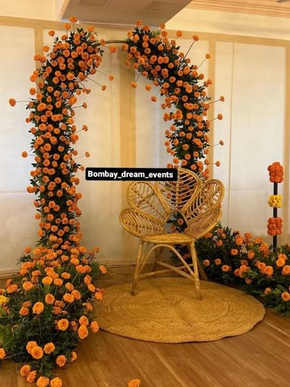 Another view of the popular boho-chic marigold arch with a cane chair, a perfect photo spot for the bride-to-be.