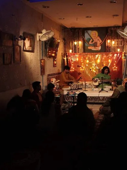 The dimly lit room creates a serene and focused environment, allowing the audience to connect deeply with the music of Sh. Arnab Bhattacharya's Sarod.