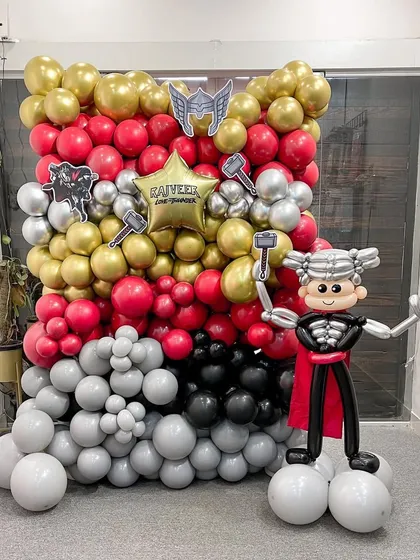 Bring the thunder with this epic Thor-themed balloon wall and sculpture. The backdrop features the hero's signature red, gold, and silver colors, while a full-body Thor balloon sculpture stands ready for action.