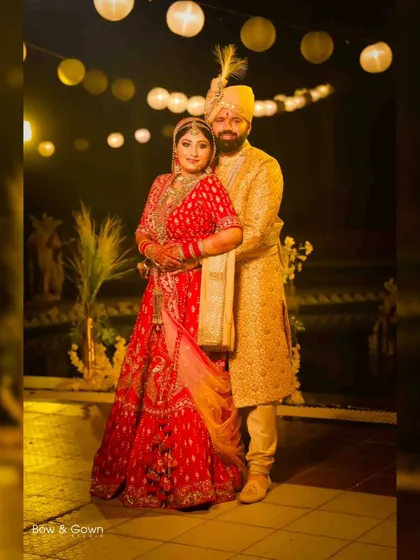 A classic portrait of the bride and groom in their wedding attire. The warm lighting and festive background create a beautiful memory of their special day.