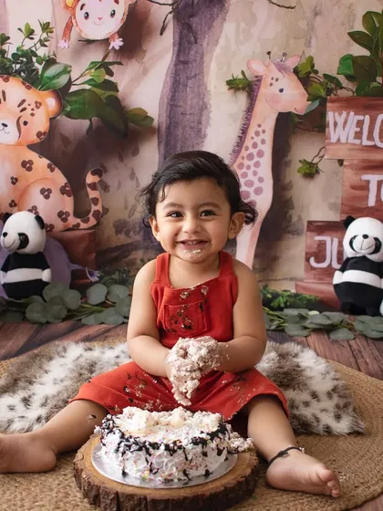 Nothing says "first birthday" like a joyful cake smash! This little one had the best time, and we captured his adorable, messy smile in our jungle-themed setup.