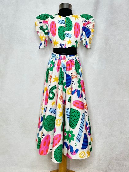 A quirky and fun lehenga featuring a print of abstract shapes. The puffed sleeves and bright colors make this a unique choice for a creative little girl.