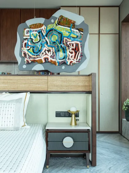 A custom-designed bed with a leather and cane headboard, created by our furniture arm, Furgonomics. A colorful hanging artwork by Bhuwal Prasad adds a playful and imaginative touch to the room.