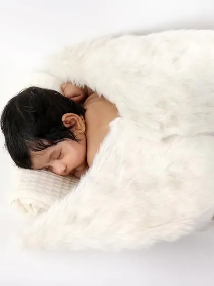 A simple and angelic portrait of a newborn with soft, fluffy wings. The focus here is entirely on the baby's peaceful expression and delicate features.