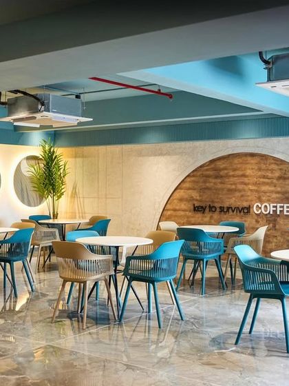 The coffee shop at the Trilogy clubhouse. We used a mix of modern chairs in shades of teal and beige, along with a curved wooden feature wall, to create a chic and comfortable spot for residents to socialize.