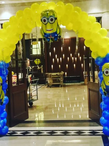 A Minions theme balloon arch for a party entrance. The blue and yellow colors and Minion character balloons make it very clear and fun for a kid's party.