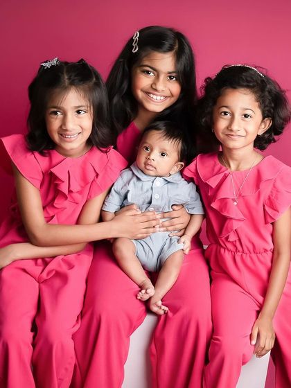 The most adorable siblings I've ever shot. The newest little brother is surrounded by his loving big sisters in this beautiful, coordinated family portrait.