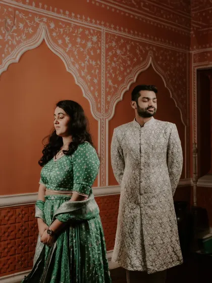 A classic, formal portrait of the couple standing side-by-side, showcasing their elegant traditional attire.