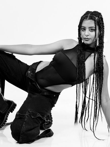 A dynamic, low-angle monochrome portrait. This shot plays with perspective and pose to create a powerful, high-fashion image.