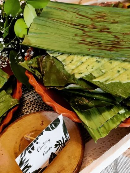 This is our Chutney Panki, a delicate and healthy Gujarati snack. A thin rice flour batter is steamed between banana leaves, making it a light and flavourful addition to any chaat party.