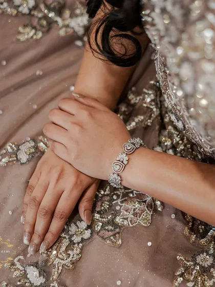 We love focusing on the intricate details, like the beautiful embroidery on Ishu's gown and her elegant bracelet. These shots add richness and texture to your final wedding album.