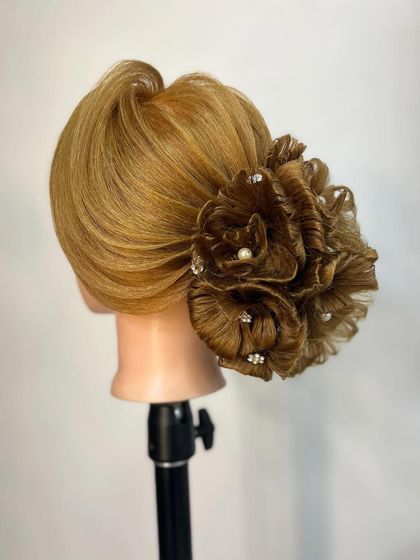 A beautifully finished floral updo, embellished with pearls and crystals. We teach how to use accessories to enhance complex hairstyles.