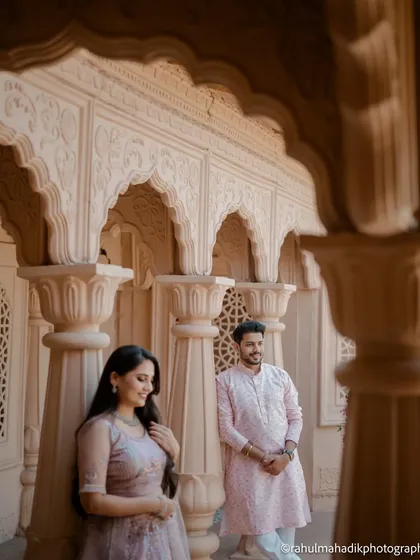 Another perspective from the same palatial location, with the groom admiring his bride. The warm sunlight and repeating arches create a dreamy, romantic atmosphere for this modern couple.