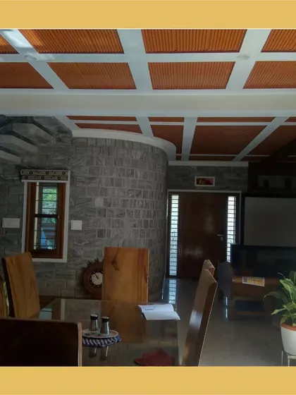 A dining area with a coffered ceiling featuring terracotta filler tiles, set against a curved stone wall.