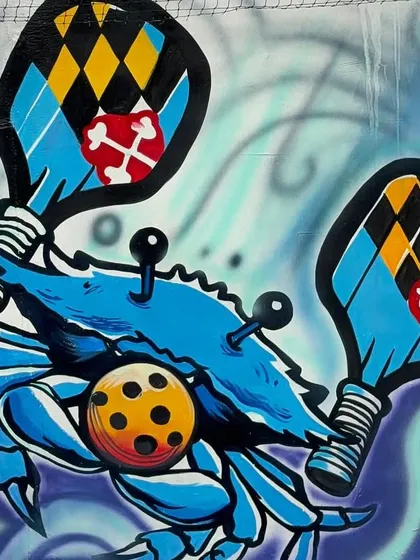 A close-up of the pickleball crab character, holding paddles. I love creating fun, custom characters for my graffiti work.