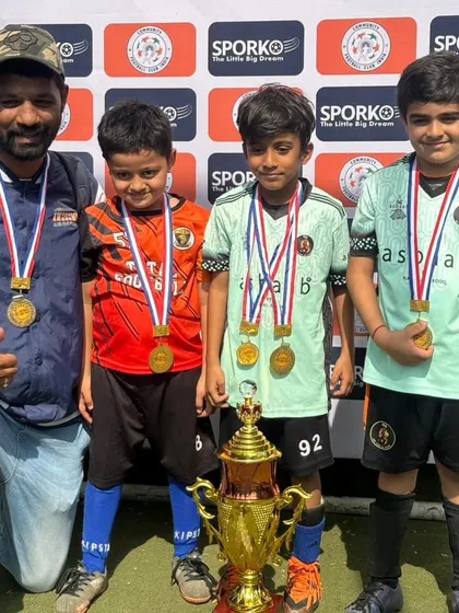 A coach and players with their medals after a double victory for our U7 and U11 teams at the Republic Cup 2024.