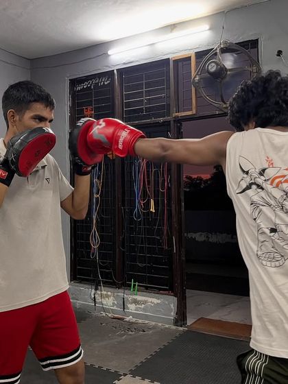 A snapshot of a focused pad work session. The student is throwing a straight right hand, and my focus is on catching it correctly to give him the right feedback.