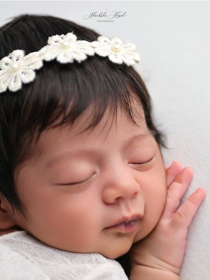 A macro shot focusing on the perfect, peaceful face of a sleeping newborn. Capturing these details, like the shape of their lips and nose, is so important.