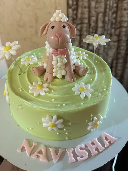 A charming sheep cake set in a field of daisies. The sheep's woolly texture is meticulously crafted from fondant, making it a sweet centerpiece for a birthday.