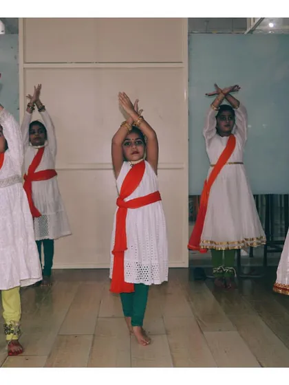 Young dancers in a graceful pose during a practice session for a cultural event, showcasing their learning and coordination.