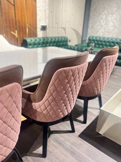 This dining set pairs a white onyx table with diamond-quilted chairs in a dusty rose velvet. The combination of the sleek, modern table and the soft, textured chairs creates a beautifully balanced look.