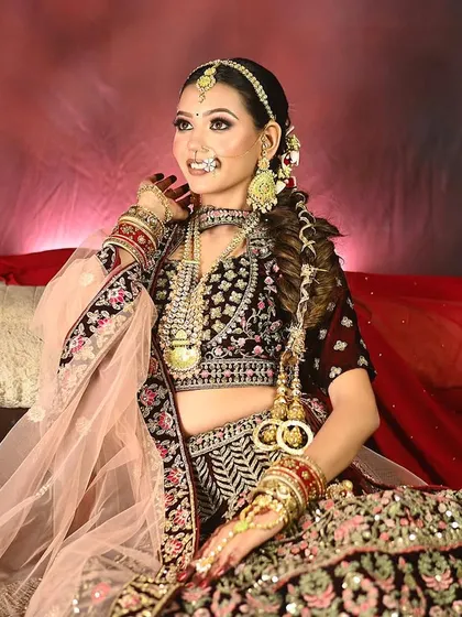 A classic bridal portrait that focuses on the model's expression and the intricate details of the jewelry and makeup. The warm, red background adds to the traditional and celebratory feel of the image.
