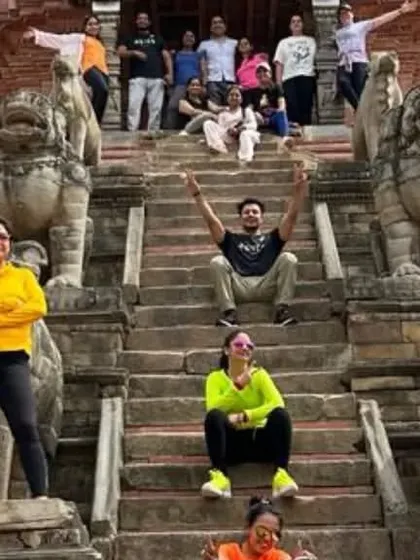 Posing on the steps of an ancient temple in Nepal. Our retreats are a blend of yoga, culture, and fun.