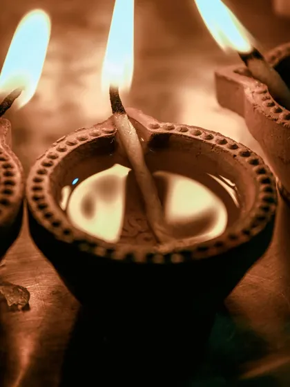 A macro shot of a traditional clay diya, its flame burning brightly. This simple yet powerful image is the essence of the festival of lights.