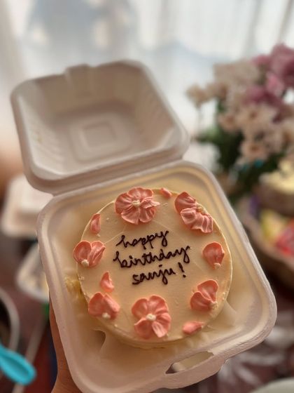 A sweet and simple floral bento cake. This one has a "Happy Birthday" message surrounded by delicate pink buttercream flowers.