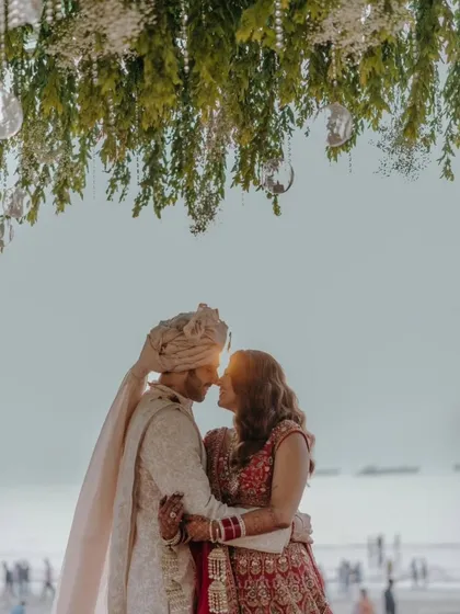 A breathtaking shot of the bride and groom. The silhouette against the setting sun is incredibly romantic, and her mehendi is a part of this picture-perfect moment.