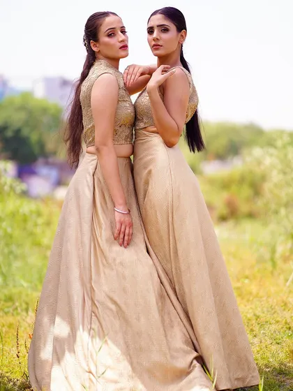 A slightly different angle of the two models, showcasing their connection and the beautiful texture of their matching outfits. This shot is perfect for a lookbook emphasizing friendship or sisterly bonds.