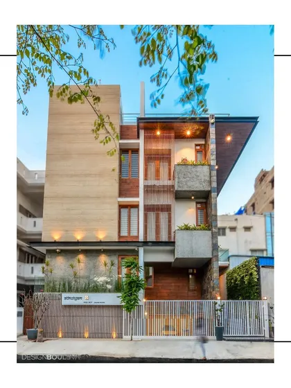 The facade of our "Athulyam" project, an early work, combines travertine marble, teak wood, and cement finishes. A triple-height slab accentuates the volume and binds the various forms of the home together.