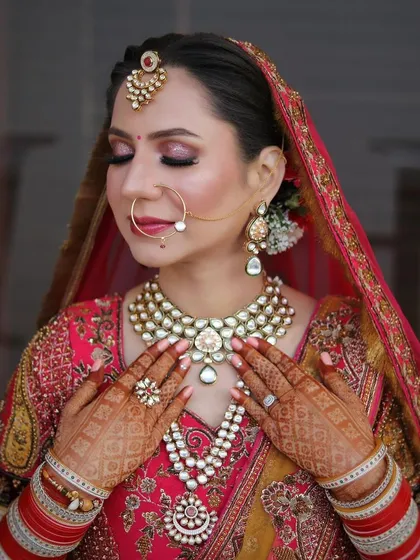 A serene portrait with eyes closed, showcasing the soft pink and gold eyeshadow work and the flawless base makeup.
