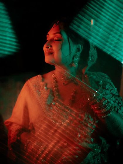 A creative shot of Shalini, with red and green lights casting a colorful, artistic glow on her.