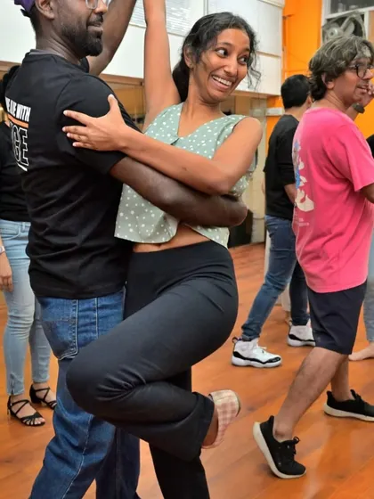 The joy of a successful move. This picture captures the smile and connection that comes from learning and growing together on the dance floor.