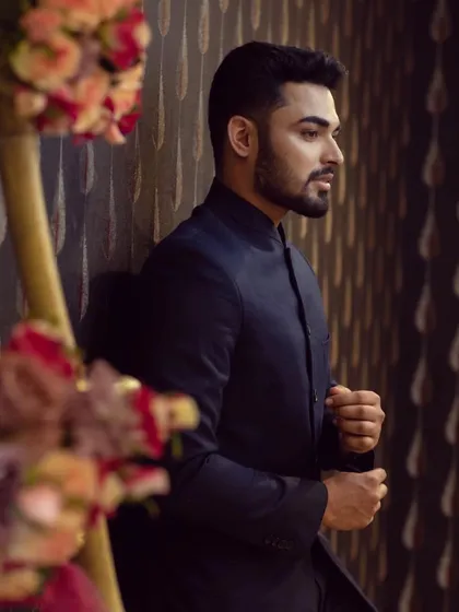 A client looking sharp and thoughtful in a classic navy blue bandhgala suit. This is a timeless choice for any formal occasion.