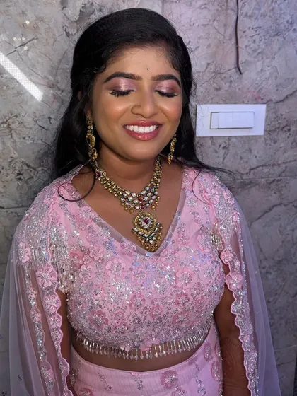 Nireeksha looking radiant for her reception. Her makeup features shimmery pink eyeshadow and a glossy lip, perfectly matching her sparkling pink lehenga.