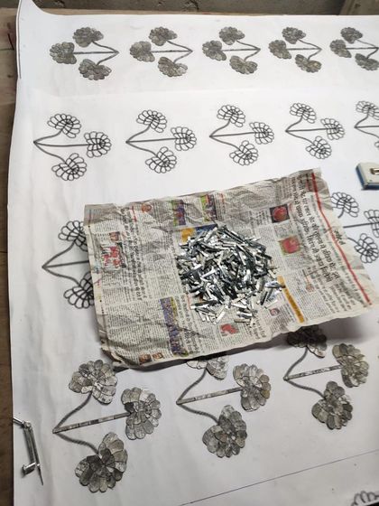 The process of creating Thikri involves sketching the design and then carefully arranging tiny, hand-cut pieces of mirrored glass. Here, the glass pieces are ready to be set.