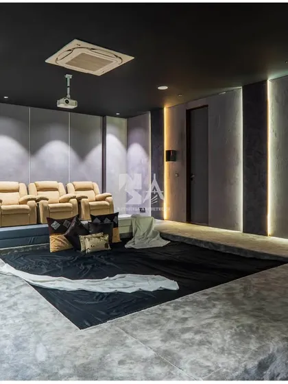 We create bespoke entertainment spaces that are both stylish and functional. This home theater is designed with tiered, dug-out seating in micro-concrete for a cozy, immersive feel, complemented by plush leather recliners. The acoustic wall paneling and integrated lighting ensure a premium cinematic experience right at home.