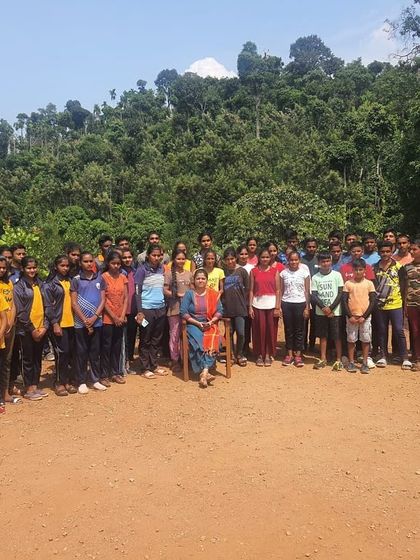 A large group of students from the KRIES summer camp gathers for a photo at our Barapole center.